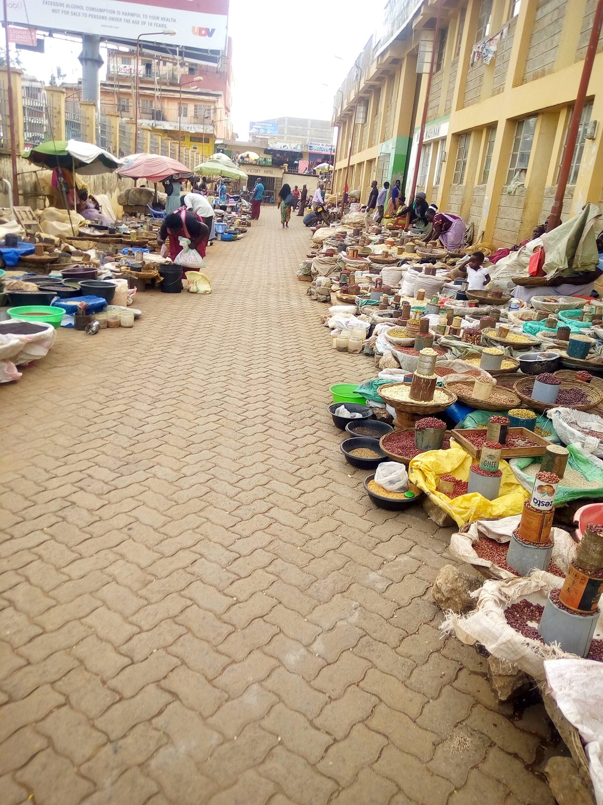 Sacks and basins of cereals at an open-air market in Kakamega County